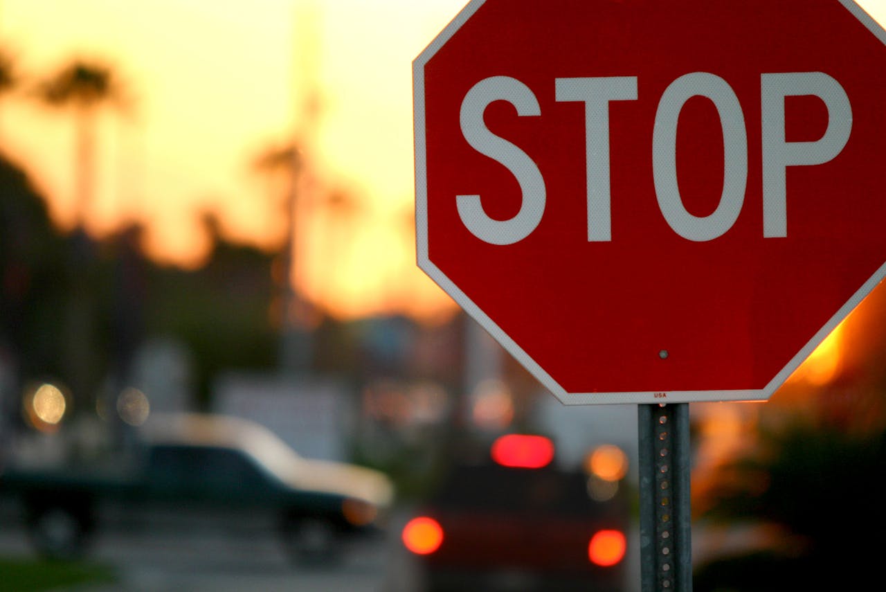 A stop sign with blurred traffic and vibrant sunset in Kissimmee, FL.